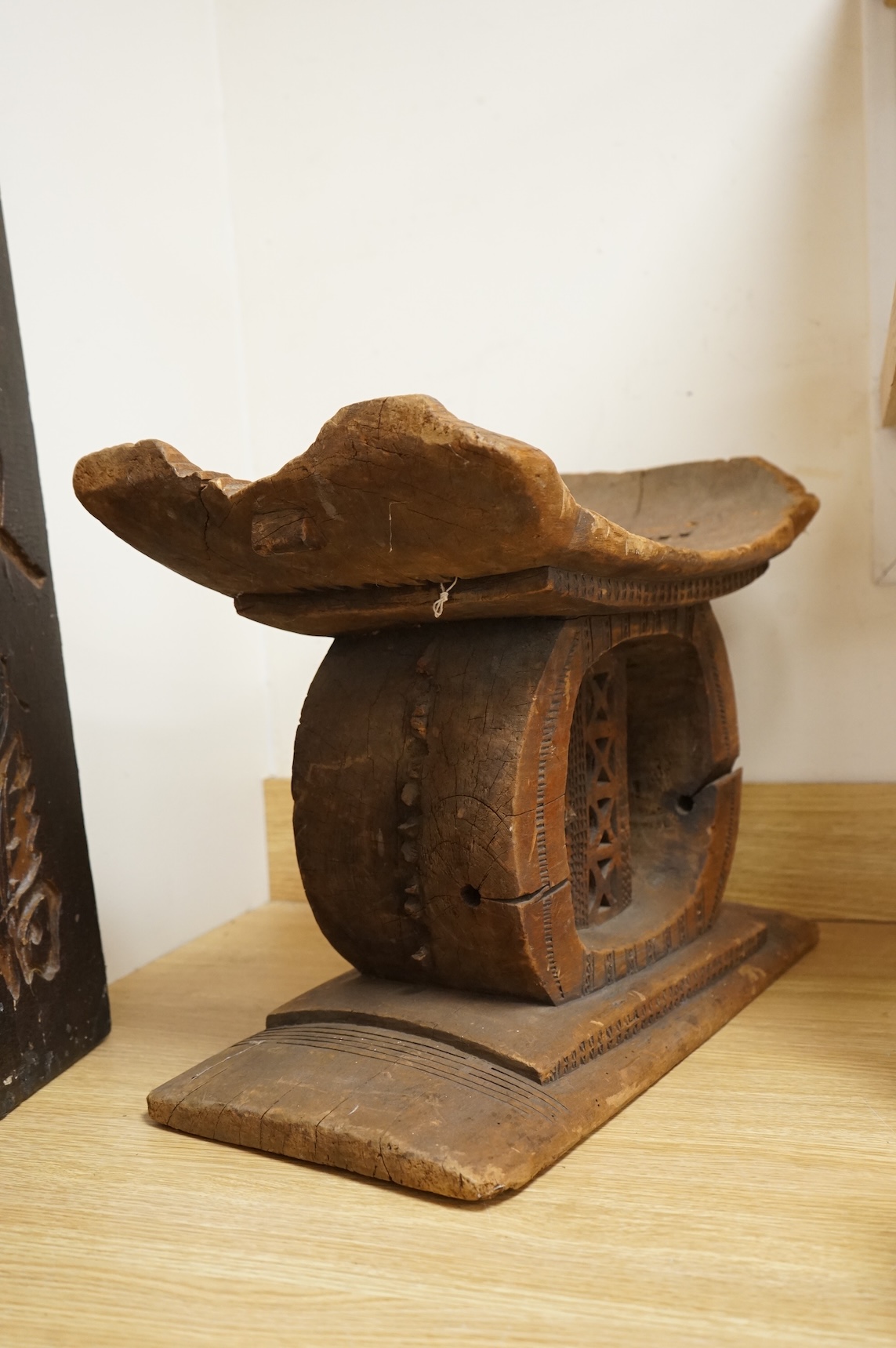 An Ashanti carved wood stool together with a similar headrest, tallest 41cm